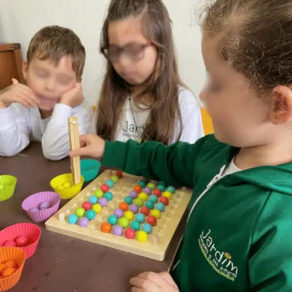 Crianças brincando com jogo de encaixe colorido